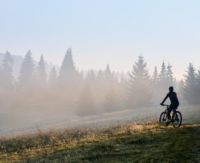 young-man-riding-bicycle-mountains-early-morning